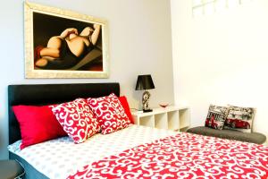 Un dormitorio con una cama con almohadas rojas y blancas. en Host Flora Sanremo, en San Remo