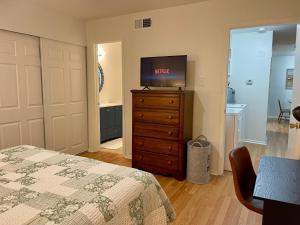 a bedroom with a bed and a tv on a dresser at Varena Condo in Lake Charles +16 photos