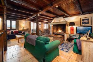 a living room with a green couch and a fireplace at Chalet Du Guide in Les Allues +5 photos