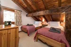 a bedroom with two beds in a room with wooden ceilings at Chalet Du Guide in Les Allues
