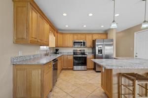a kitchen with wooden cabinets and stainless steel appliances at Maldonado Beach House in Pensacola Beach