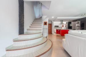 een trap in een woonkamer met een bank en een keuken bij Encanto Arinaga in Cruce de Arinaga