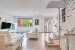 een woonkamer met witte meubels en een televisie bij Encanto Arinaga in Cruce de Arinaga