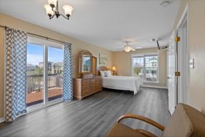 a bedroom with a bed and a balcony at Maldonado Beach House in Pensacola Beach