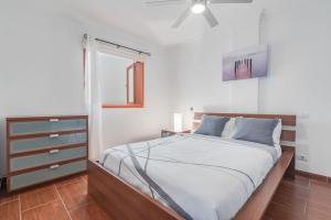 een slaapkamer met een bed en een plafondventilator bij Encanto Arinaga in Cruce de Arinaga