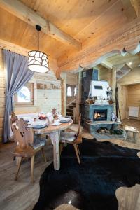 comedor con mesa y chimenea en Przystań w Tatrach - Przytulne Domki i Apartamenty-Luxury Chalets and Apartments, en Bukowina Tatrzańska