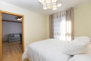 Una habitación blanca con una cama y una ventana en Casa Lite by BeValle, en Escarrilla