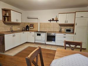 a kitchen with white cabinets and a table and chairs at Ferienwohnung Schindler in Nittenau