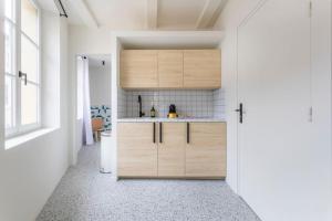 a kitchen with wooden cabinets and a sink at 3CAPU3 - Cosy T2 refait à neuf - Noaille in Marseille +7 photos