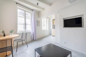 a living room with a table and a tv at 3CAPU3 - Cosy T2 refait à neuf - Noaille in Marseille