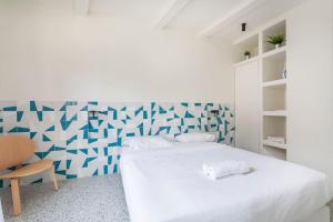 a white bedroom with a blue and white patterned wall at 3CAPU3 - Cosy T2 refait à neuf - Noaille in Marseille