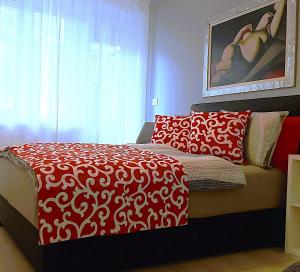 Un dormitorio con una cama roja y blanca y una ventana en Host Flora Sanremo, en San Remo