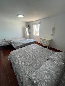 a room with two beds and a table and a window at ALMAFUERTE in Mijas