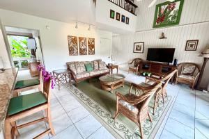 a living room with a couch and chairs and a tv at Pali Ke Kua #9 in Princeville