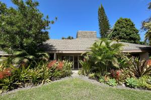 a house with trees and plants in front of it at Pali Ke Kua #9 in Princeville