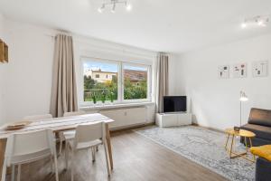 a white living room with a table and a window at WIESE 18 im Cottbuser Süden in Cottbus