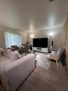 a living room with a couch and a tv at Banquet Hotels Tacoma-Lakewood-Puyallup-DuPont-Lacey-Olympia in DuPont