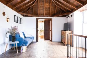 a living room with a blue couch and a tv at Casa Rai: ¡Déjate sorprender! in San Andrés