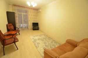 een woonkamer met een bank en stoelen en een televisie bij Lux Apartment Sobornaya in Nikolayev