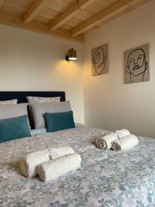 a bedroom with a bed with towels on it at Le petit chalet de la Ronzière de Miss K in Cormoranche-sur-Saône