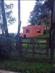 ein kleines rotes Haus hinter einem Holzzaun in der Unterkunft Casa Naranja in San Javier