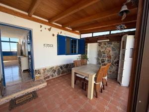 a kitchen with a wooden table and some chairs at Casa del Sur good vibes only in Costa Calma