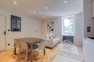 a living room with a table and a couch at Superbe appartement, deux chambres, St-Didier in Saint-Didier-au-Mont-dʼOr