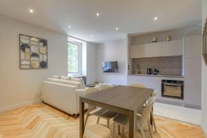 a kitchen and living room with a table and a couch at Superbe appartement, deux chambres, St-Didier in Saint-Didier-au-Mont-dʼOr