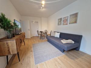 a living room with a blue couch and a table at Ferienwohnung in Krefeld in Krefeld