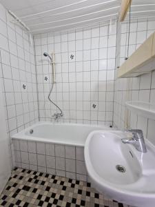 a white bathroom with a tub and a sink at Ferienwohnung in Krefeld in Krefeld +16 photos