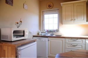una cucina con forno a microonde e lavandino di Skellig Port Accomodation - 2 Bed Apartment a Portmagee