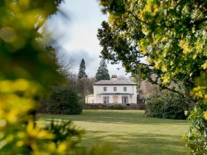 una gran casa blanca en un campo con árboles en YHA Hawkshead, en Hawkshead