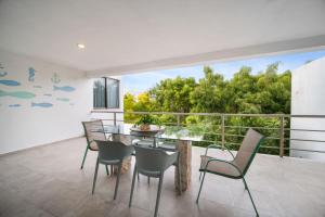 a dining room with a glass table and chairs on a balcony at San Bruno TROPICAL Villa With POOL in San Bruno