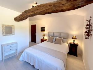 a bedroom with a white bed and a wooden ceiling at Lac privé, forêt, calme absolu dans un gîte tout confort in Saint-Estèphe