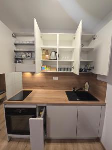 a kitchen with white cabinets and a sink at Like home, Coffee or Tea & Parking free in Trnávka