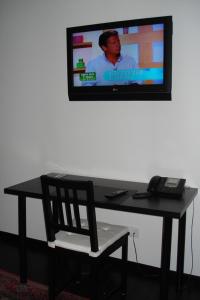 a desk with a chair and a television on a wall at B&B La Chapelle Au Puits in La Louvière