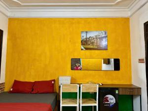 a living room with a couch and a yellow wall at House with balcony,K Home 1,Old Quarter,3 mins to Hoankiem Lake in Hanoi