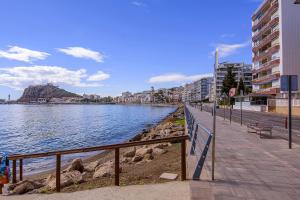 アギラスにあるÁguilas Delicias Piscina Wifi AC Parking Gratisの建物の水の横の歩道