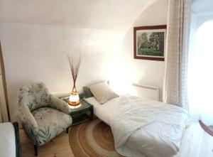 een slaapkamer met een bed en een stoel bij "La Voûte de Pierre" Gîte indépendant in Saint-Cyr +42 foto's
