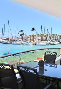 a table and chairs with boats in a marina at Simply Astonishing Location in Benalmádena