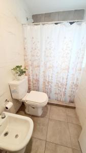 a bathroom with a toilet and a shower curtain at Sundara Tan perfecto que no vas a querer irte in Villa Carlos Paz +16 photos