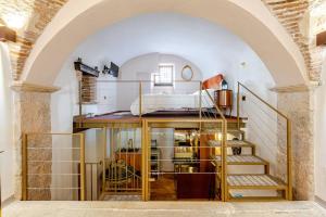 Habitación con cama y escaleras en un edificio en Art of Living, Elegante casa nel centro storico, en LʼAquila