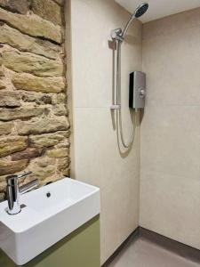 a bathroom with a sink and a stone wall at The Retreat in Eccleston +60 photos