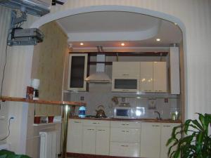 ヴィーンヌィツャにあるApartment On Sobornayaの白いキャビネットと大きな鏡付きのキッチン