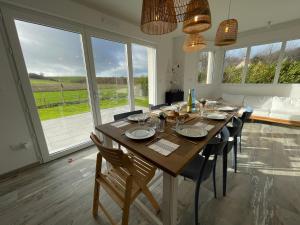 a dining room with a table and chairs and windows at Villa 800 in Wissant