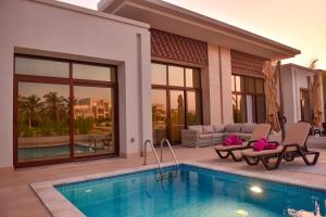 eine Villa mit Swimmingpool und einem Haus in der Unterkunft Segal Rotana Salalah Villa with private swimming pool in Salalah