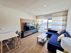 a living room with a blue couch and a tv at SR Wellingtonia Estepona Centro in Estepona