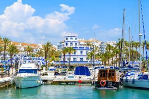 a group of boats docked in a marina with a building at SR Wellingtonia Estepona Centro in Estepona