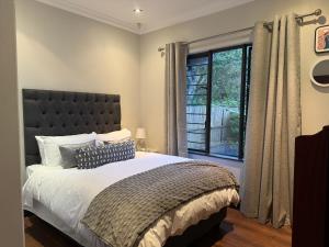 een slaapkamer met een groot bed en een raam bij Robyns Nest Self Catering Cottage No4 in Gillitts