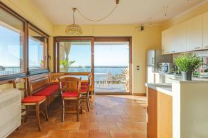 a kitchen with chairs and a table with a view of the ocean at Appartamento in villa con terrazza vista mare - pet friendly in Trieste
